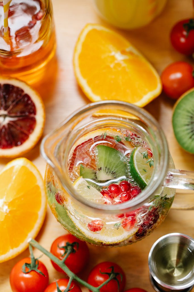 Glass pitcher with vibrant citrus and kiwi fruits creating a refreshing drink.